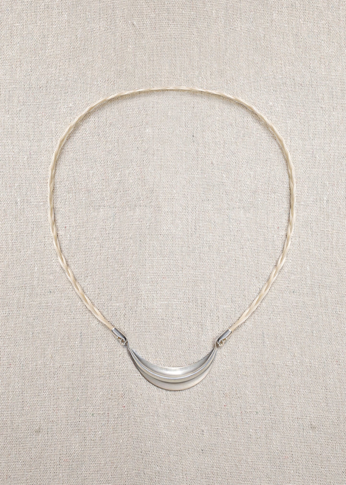 Delicate RIVERLAKE crescent necklace with a polished finish and adjustable chain, elegantly displayed on a soft background.