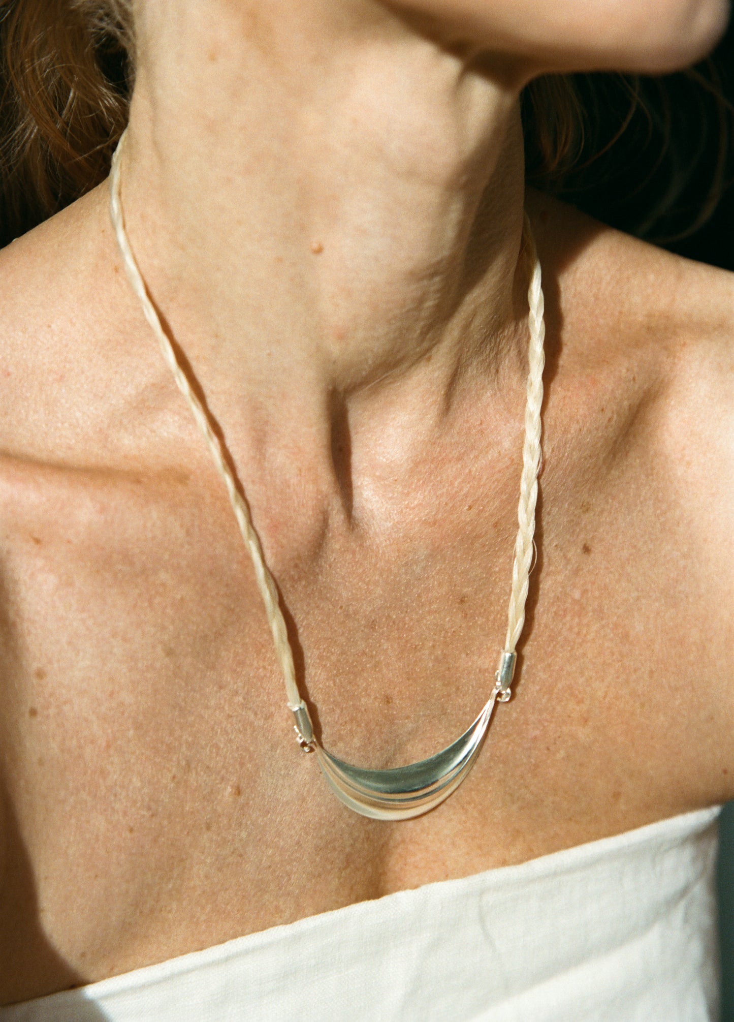 Silver crescent necklace by RIVERLAKE with delicate chain and polished finish, displayed against a neutral background.