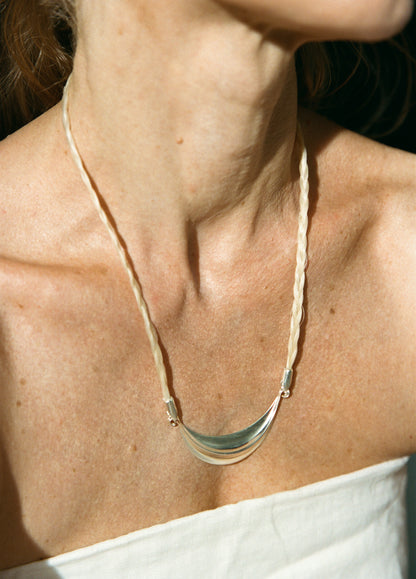 Silver crescent necklace by RIVERLAKE with delicate chain and polished finish, displayed against a neutral background.