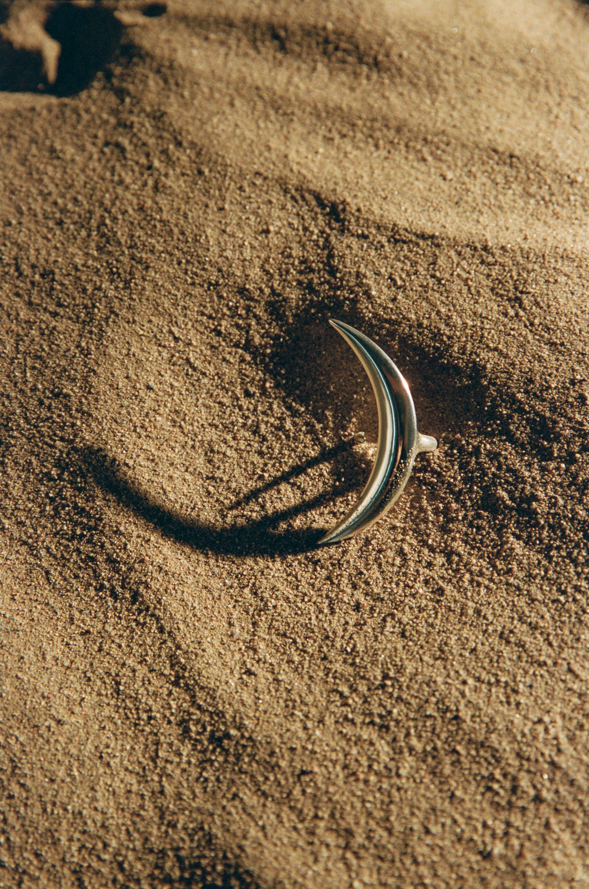 Silver moon ring by RIVERLAKE with a textured surface and crescent design, set against a soft-focus background.