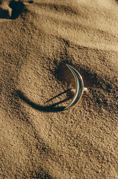 Silver moon ring by RIVERLAKE with a textured surface and crescent design, set against a soft-focus background.