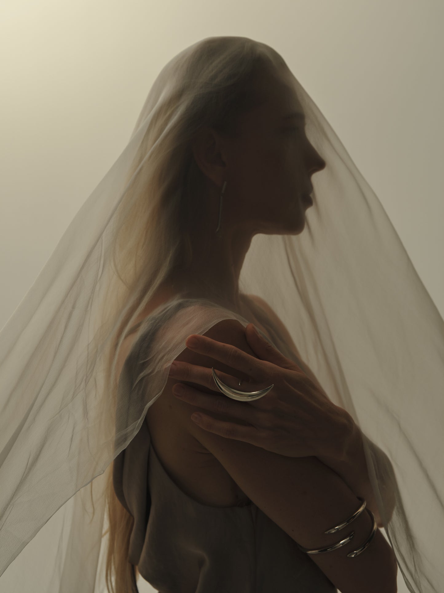 Silver moon ring by RIVERLAKE featuring a textured crescent design and polished finish, set against a dark background.