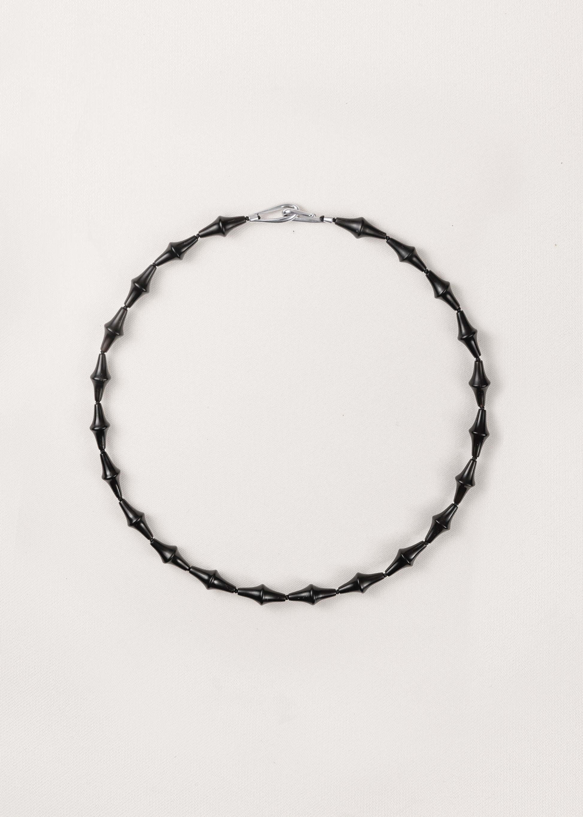 RIVERLAKE Nyx necklace featuring a unique black buffalo horn design, elegantly displayed on a neutral background.