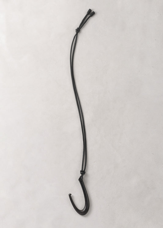 RIVERLAKE Hook Pendant in Ebony with a sleek, modern design and a polished finish hanging on a minimalist display.