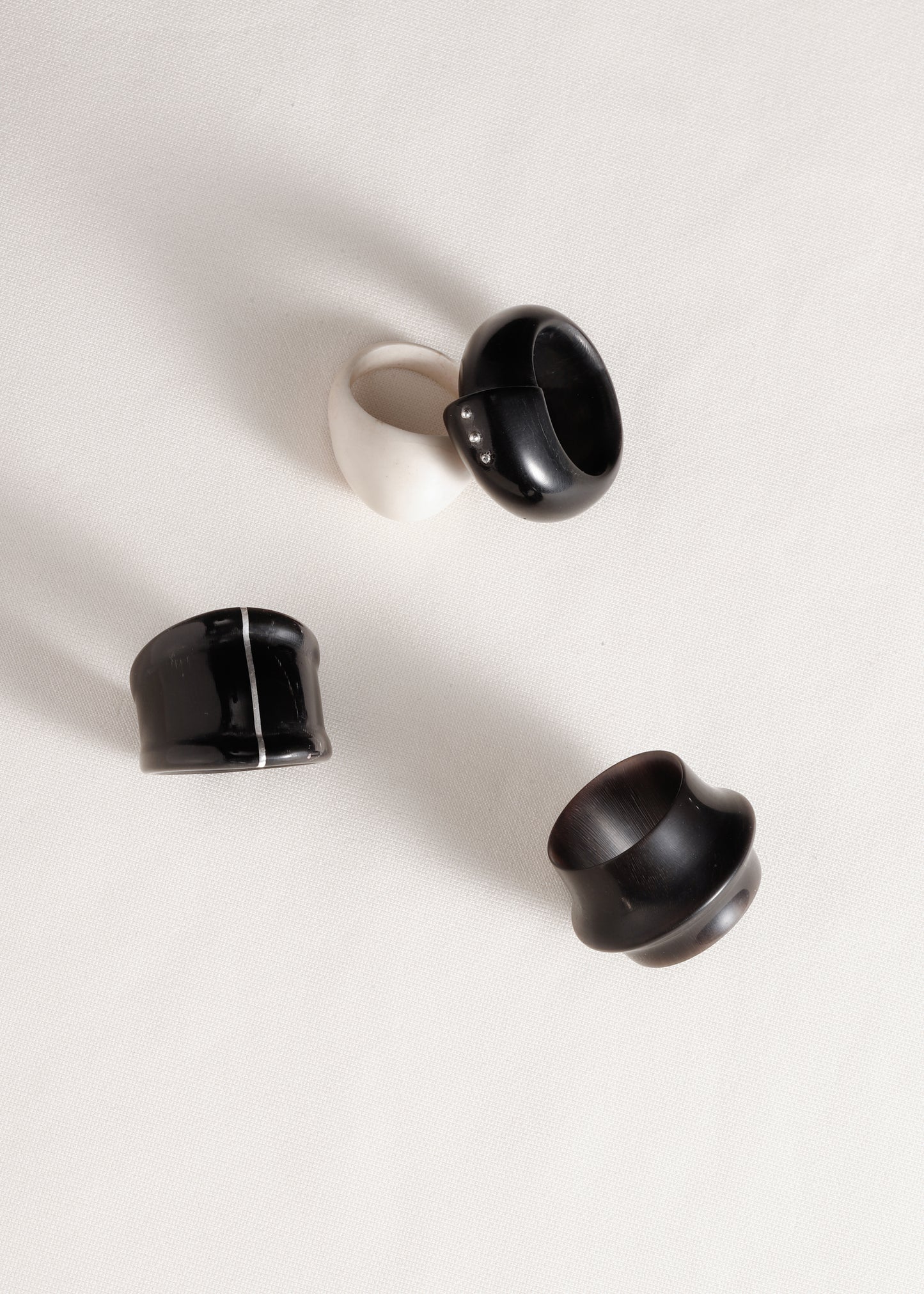 Black buffalo horn curl ring with silver rivets by RIVERLAKE, showcasing a unique and stylish design.
