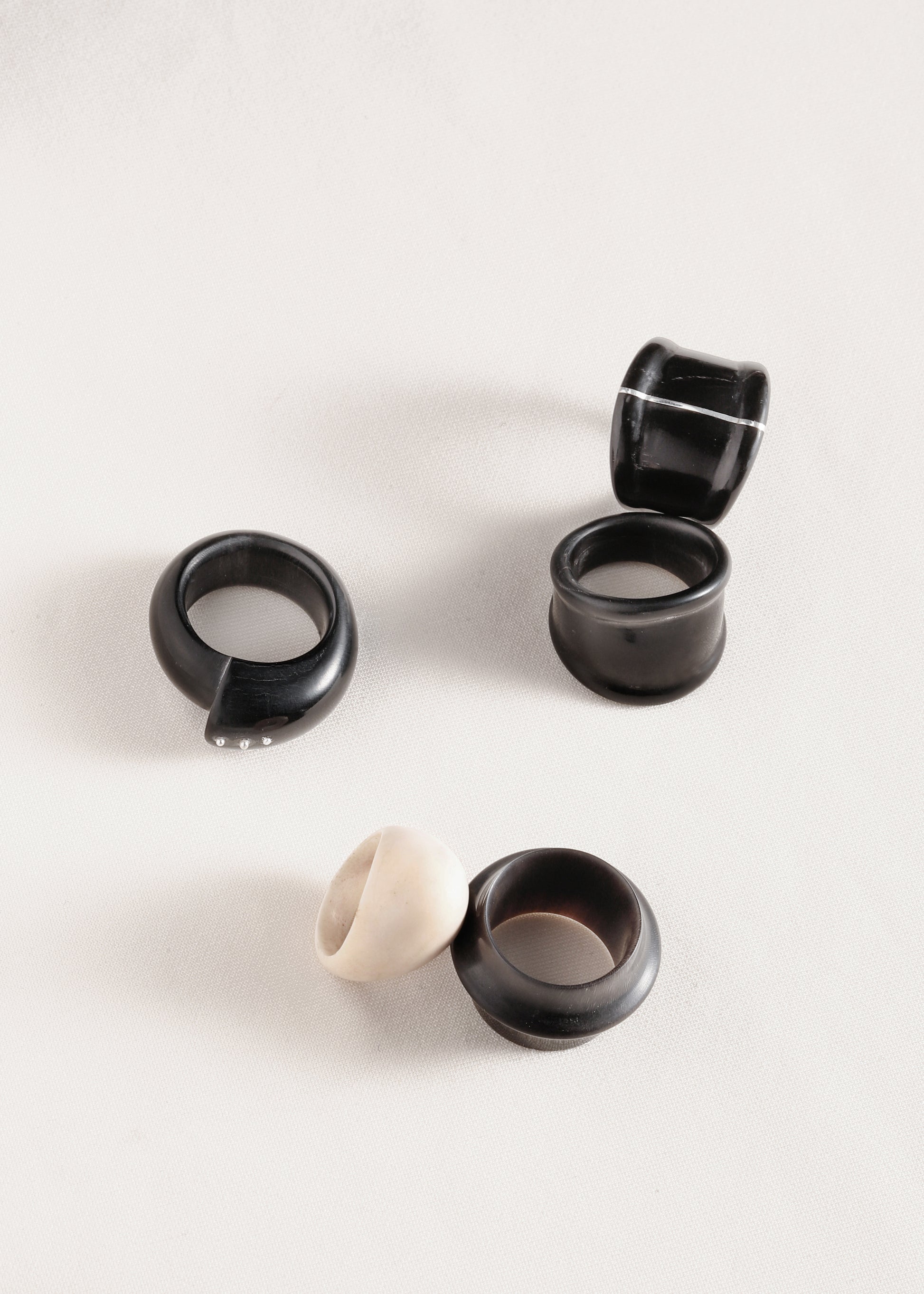 Black buffalo horn curl ring with silver rivets by RIVERLAKE, showcasing an elegant and unique design.