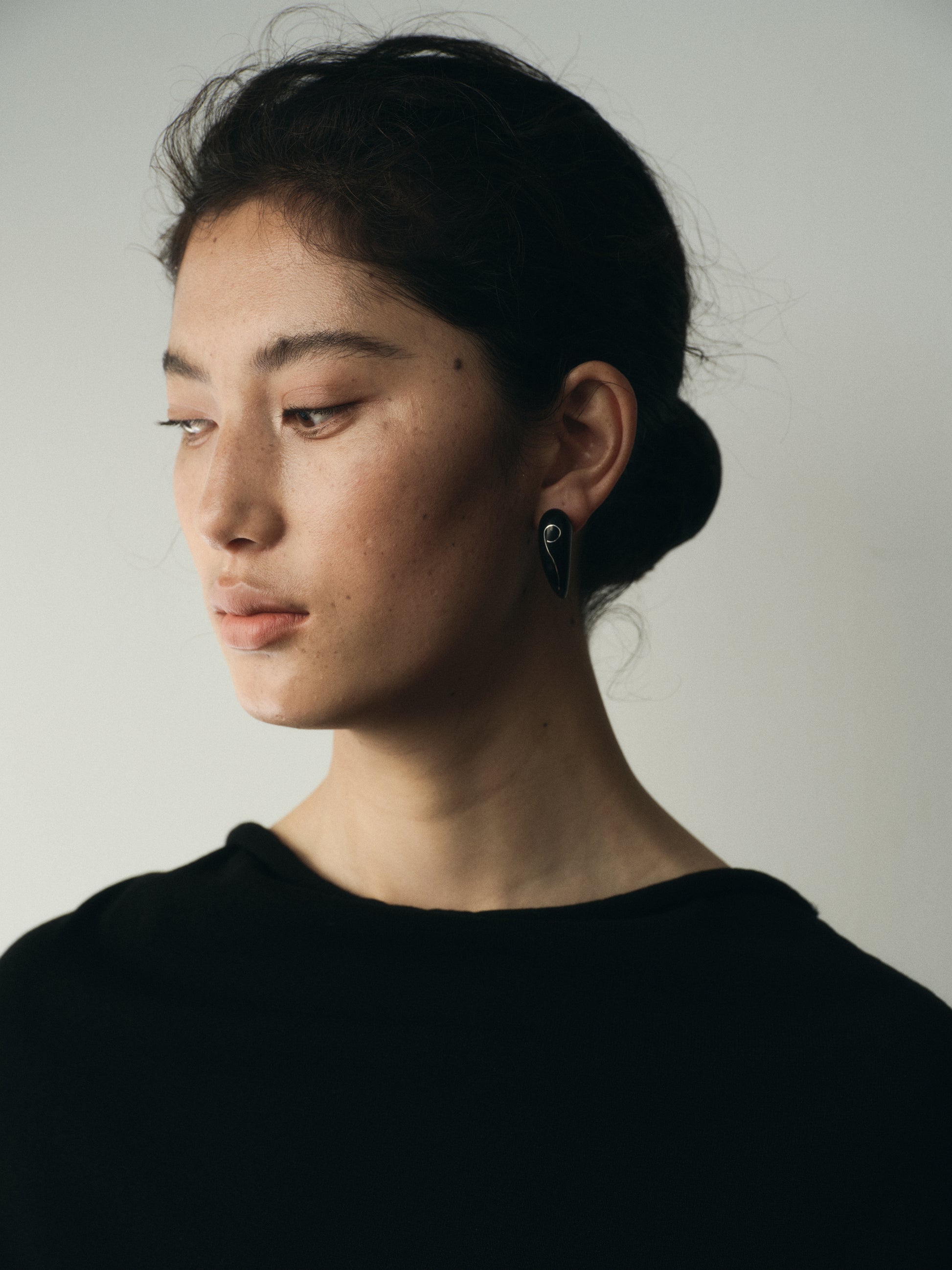 Medium fang earrings made of black buffalo horn with silver inlay by RIVERLAKE, showcasing unique design and craftsmanship.