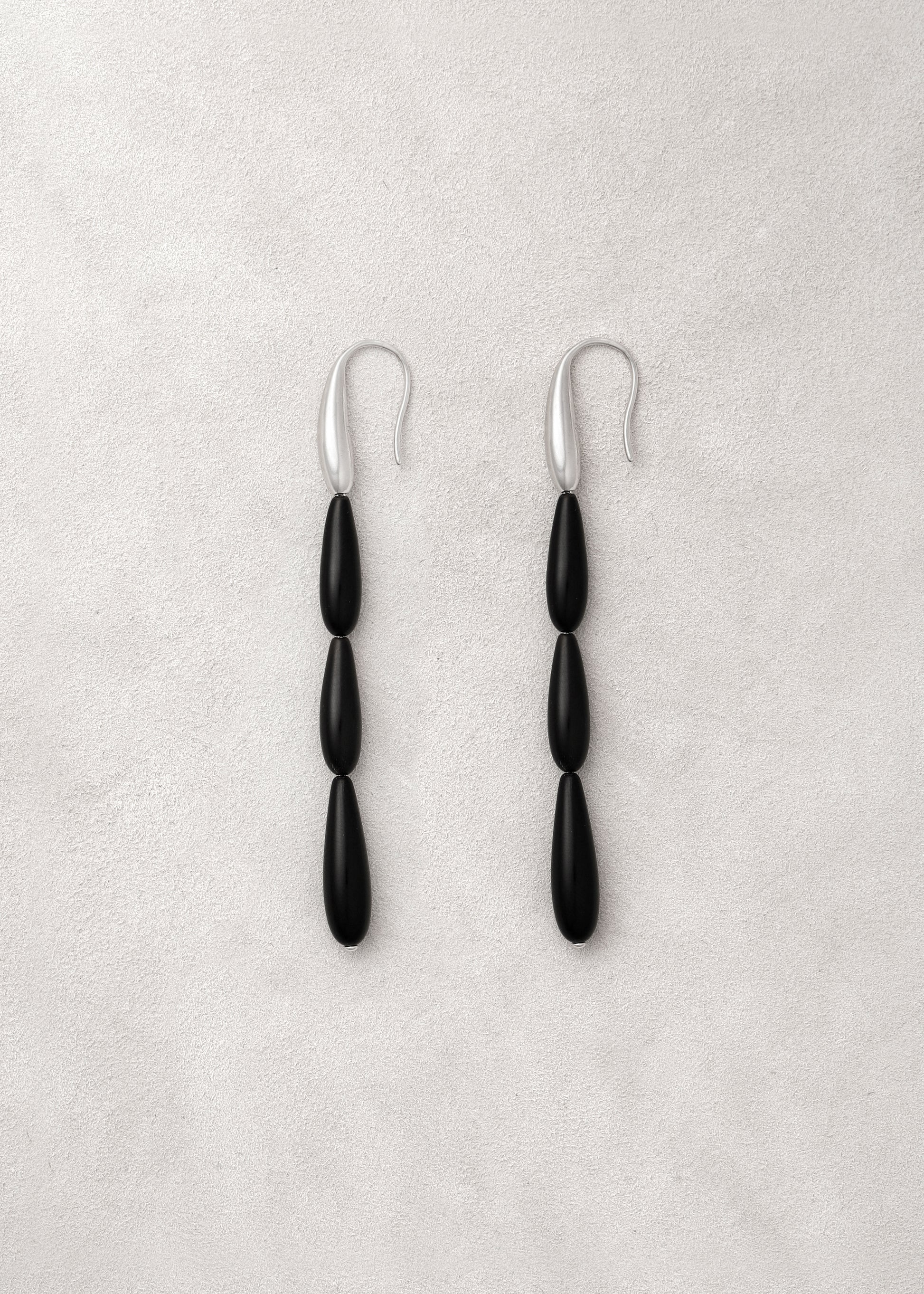 Long spring earrings made of black buffalo horn by RIVERLAKE, showcasing their elegant design and unique texture.