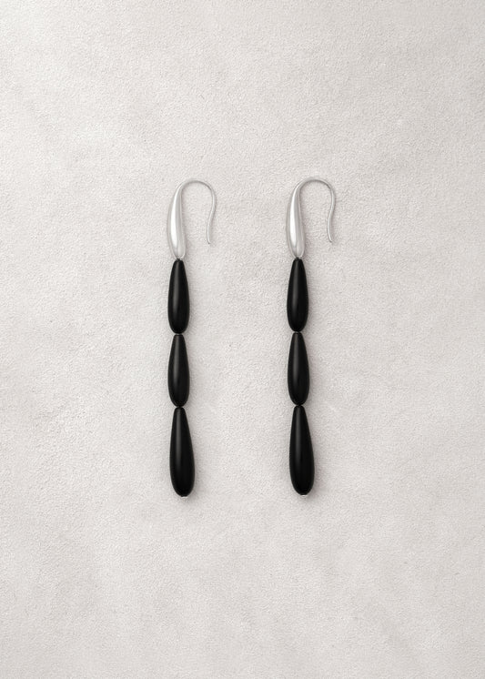 Long spring earrings made of black buffalo horn by RIVERLAKE, showcasing their elegant design and unique texture.
