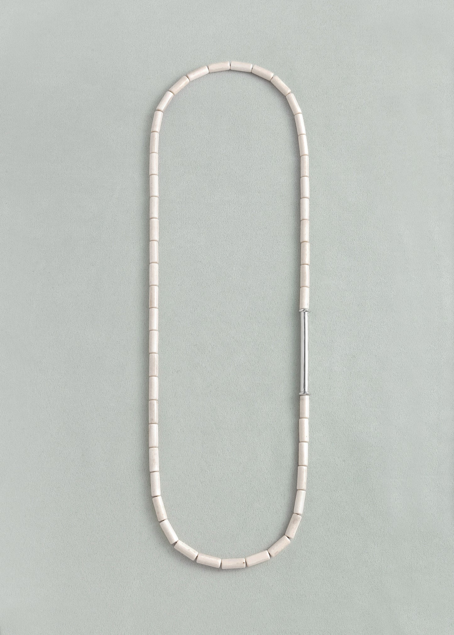 Antler River Rhythm Necklace by RIVERLAKE featuring delicate design and natural hues, displayed elegantly.