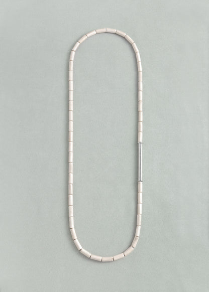 Antler River Rhythm Necklace by RIVERLAKE featuring delicate design and natural hues, displayed elegantly.