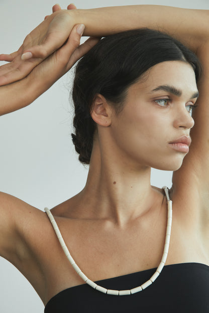 River Rhythm Necklace by RIVERLAKE featuring an antler pendant on a delicate chain against a neutral background.